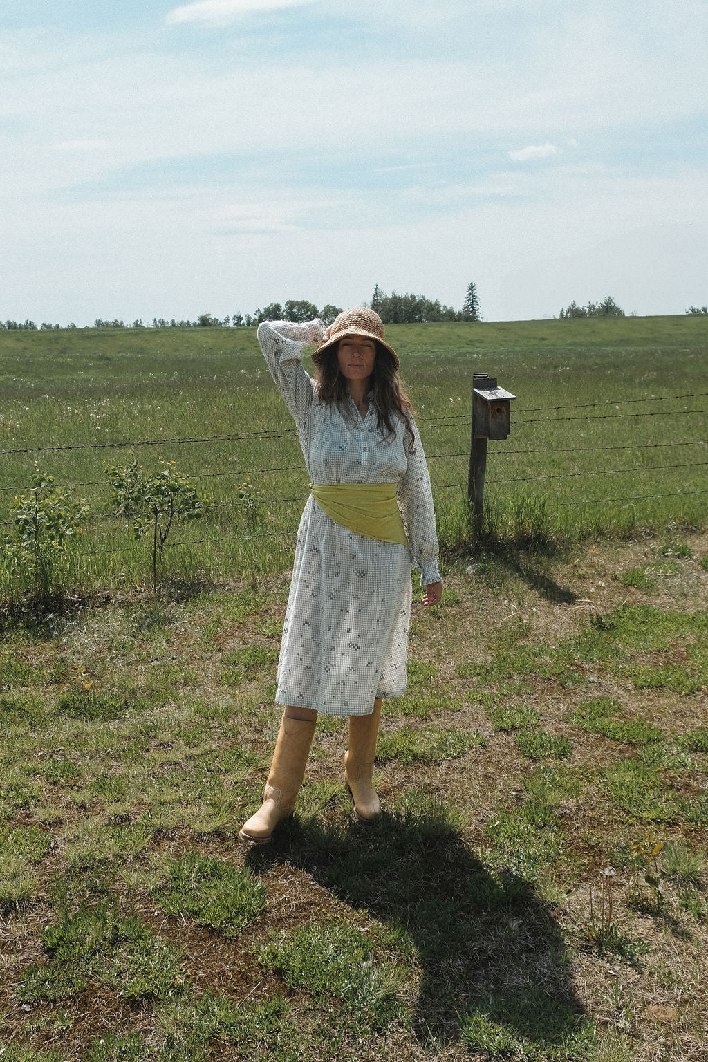 This Jamdani dress made with handwoven cotton is a perfect summer dress with its light color detailed square black threads. It has long sleeves with ruffles along a ruffled neck, and a midi length. 